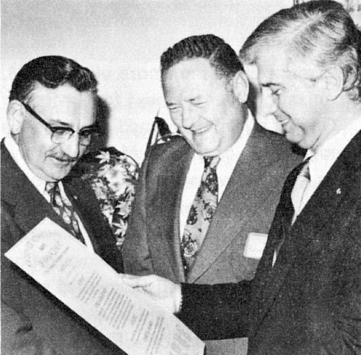 Black and White Photograph of Hal Batten (I.) and Donald Begosh (r.), S.A.M. international chairman and executive director, respectively, share smiles and congratulations with James Rutherford, president of the new Montgomery chapter, as they present Rutherford with the new charter.