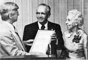 Harold McClellan (c.) receives the 1976 International Human Relations Award from Donald Begosh (I.), S.A.M. executive director, as McClellan's wife, Katherine, looks on.
