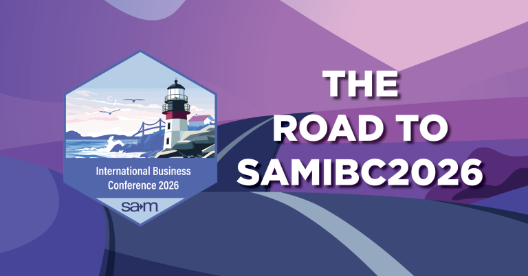 A stylized purple and pink landscape with a dark winding road leading toward distant hills under a pastel sky. On the left is a hexagonal badge featuring a lighthouse by the sea with the text ‘International Business Conference 2026 SAM.’ Overlaying the scene in bold white letters is ‘The Road to SAMIBC2026.