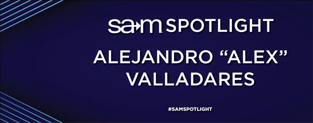 Dark blue graphic with diagonal light blue lines in the corners. The text in the center reads “SAM Spotlight” at the top and “Alejandro ‘Alex’ Valladares” in bold white letters in the middle. At the bottom is the hashtag #SAMSPOTLIGHT.